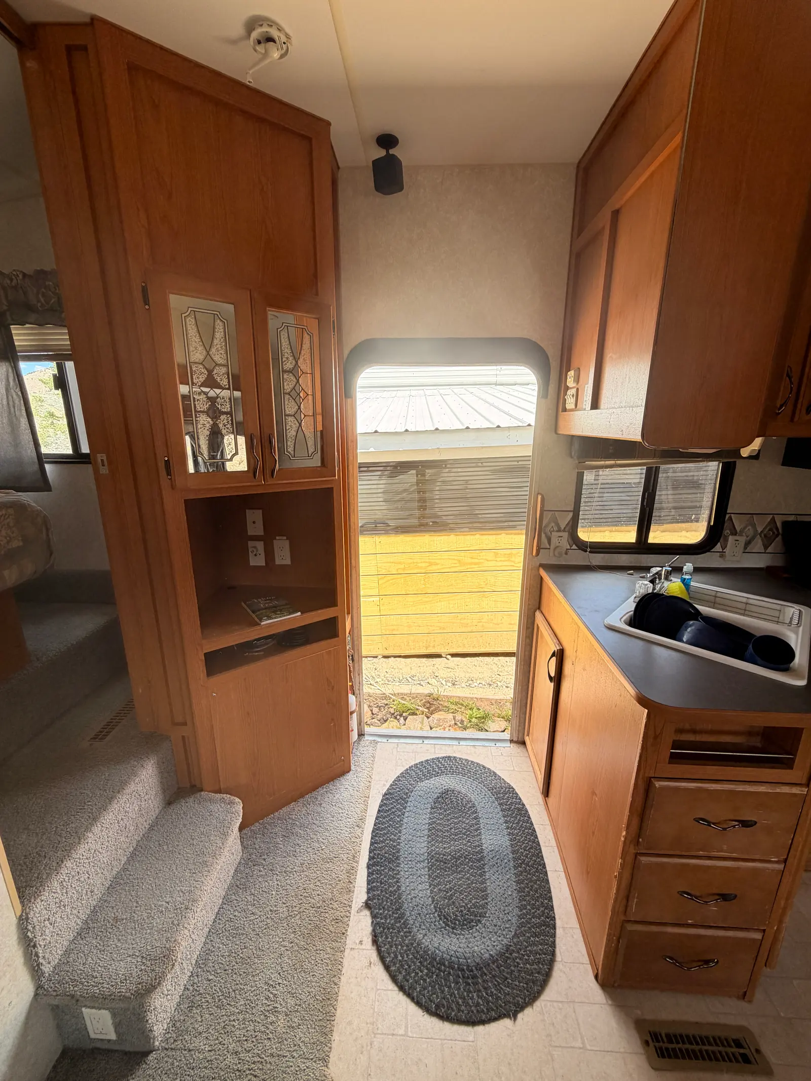 Looking down the fifth wheel hallway from the bedroom steps toward the galley and living area